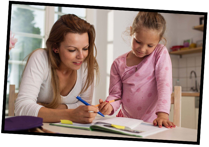 Frau liest ihrer Tocher aus einem Buch vor.